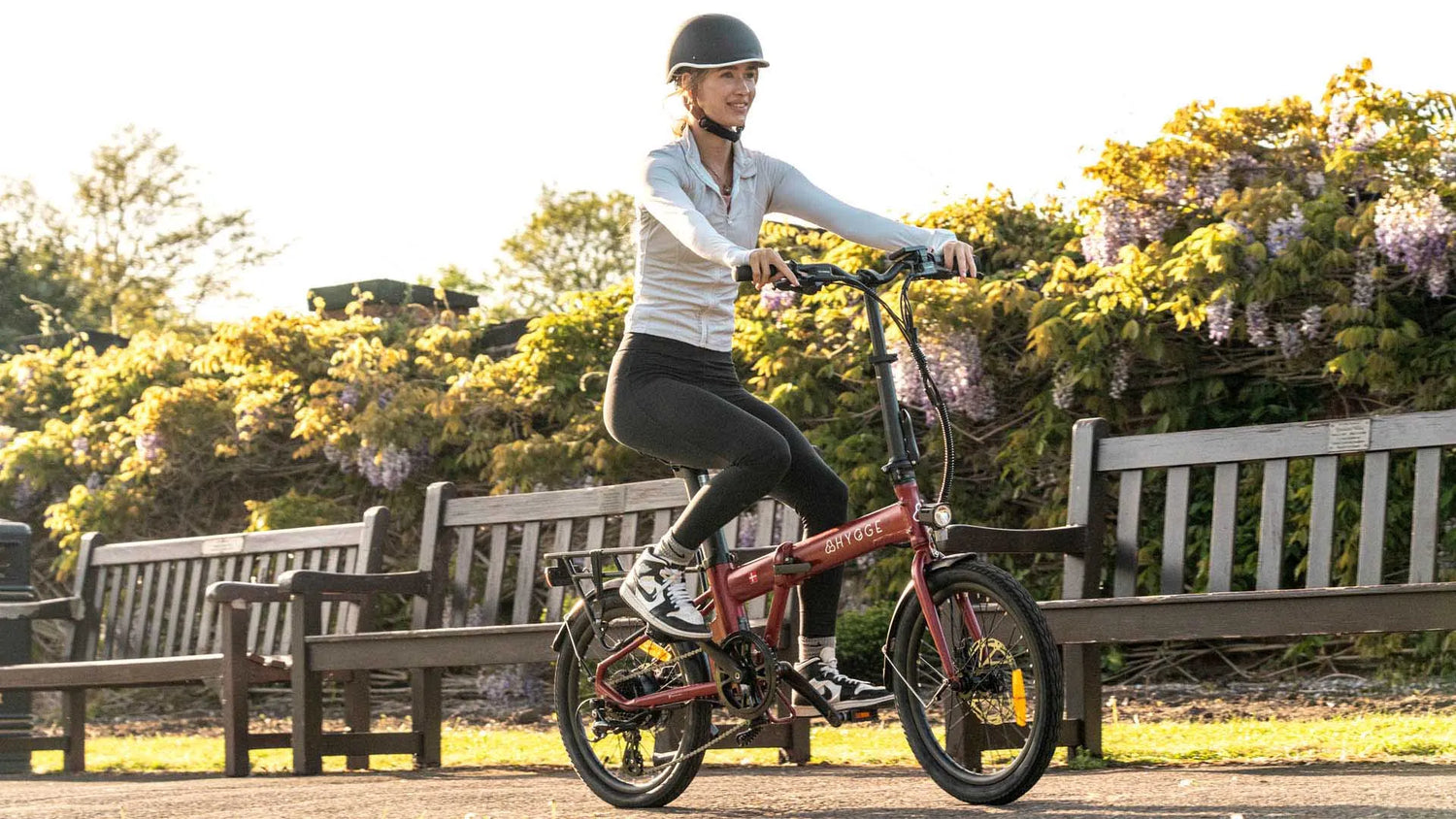 Woman riding the Hygge Virum lightweight folding e-bike, showcasing comfort and everyday practicality
